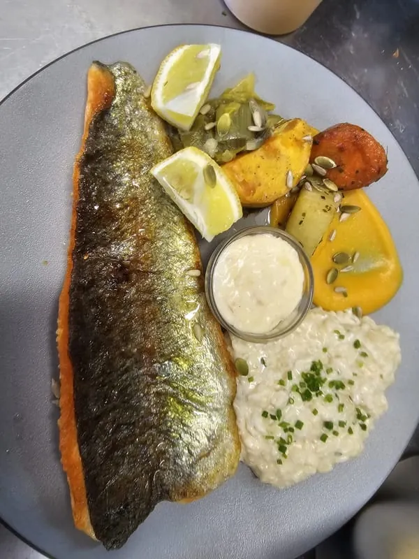 Poisson servi avec sa sauce et ses légumes